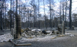 A Bastrop County home is burnt to the ground. All that remains of the structure is two brick walls, charred appliances and ash.