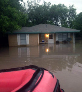 A rescue craft approaches a home in Williamson County during a flood event.